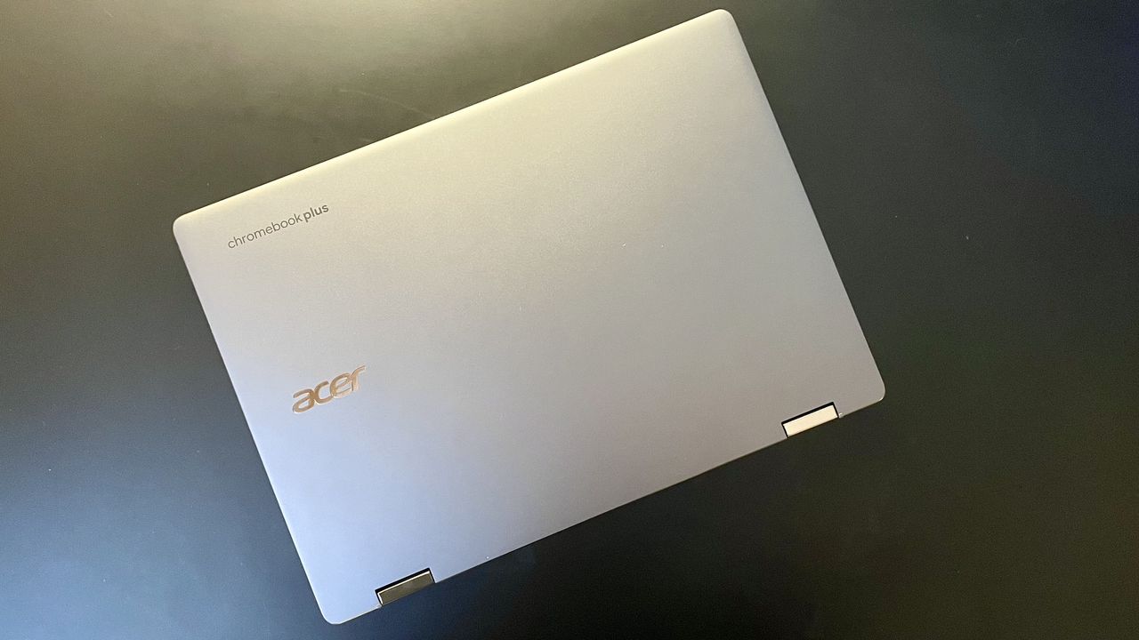 A top-down of a closed laptop on top of a black surface.