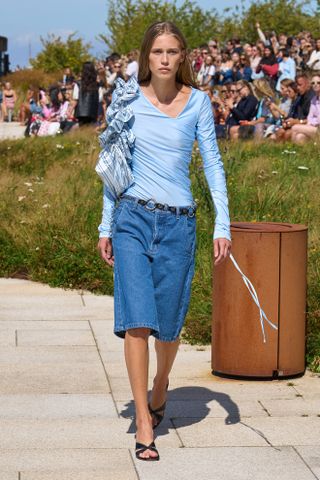 model wearing a blue shirt and bermuda shorts on the OperaSPORT Spring 2025 runway