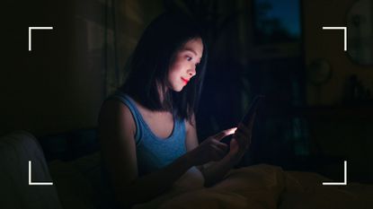Woman sitting on phone in the middle of the night, wondering how to get back to sleep