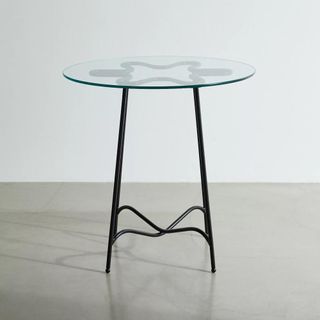A round metal table with a glass top 