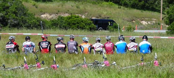 The pro men started sitting with their backs to their bikes