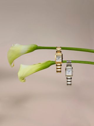 One gold Citizen Bianca watch and one silver Citizen Bianca watch hanging from flowers.