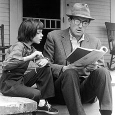 Man reading to little girl on porch