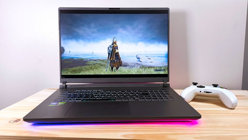 The Asus ROG Strix G18 running Elden Ring Nightreign on a wood table beside a white Xbox controller