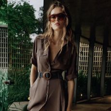 Woman wears shirt dress with belt and sunglasses all from Zara
