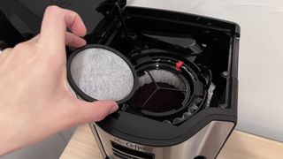 adding in the filter to the Mr. Coffee 12 Cup Programmable Coffee Maker