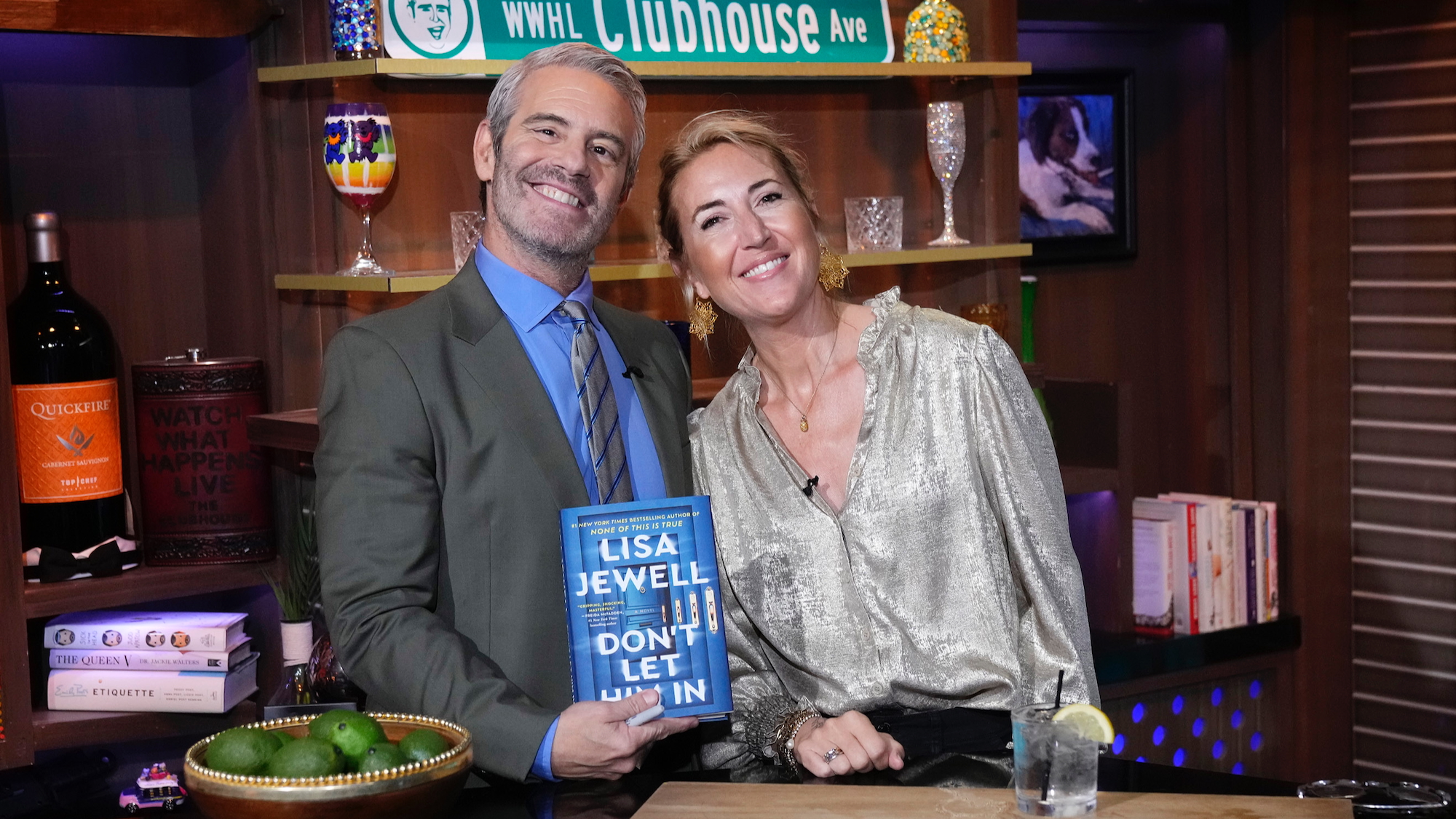 Author Lisa Jewell smiles alongside TV host Andy Cohen, who holds her new book Don't Let Him In, after discussing it on Season 22 episode 107 of his TV show Watch What Happens Live With Andy Cohen, in June 2025