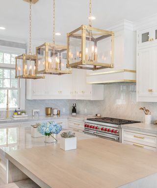 white kitchen with gold effect and glass lanterns above island, white units, gold effect accents,