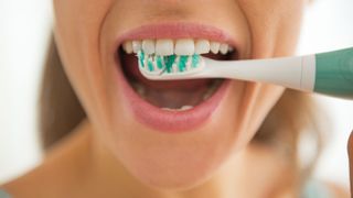 Woman smiling and brushing teeth