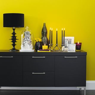 dining room with yellow wall and black sideboard