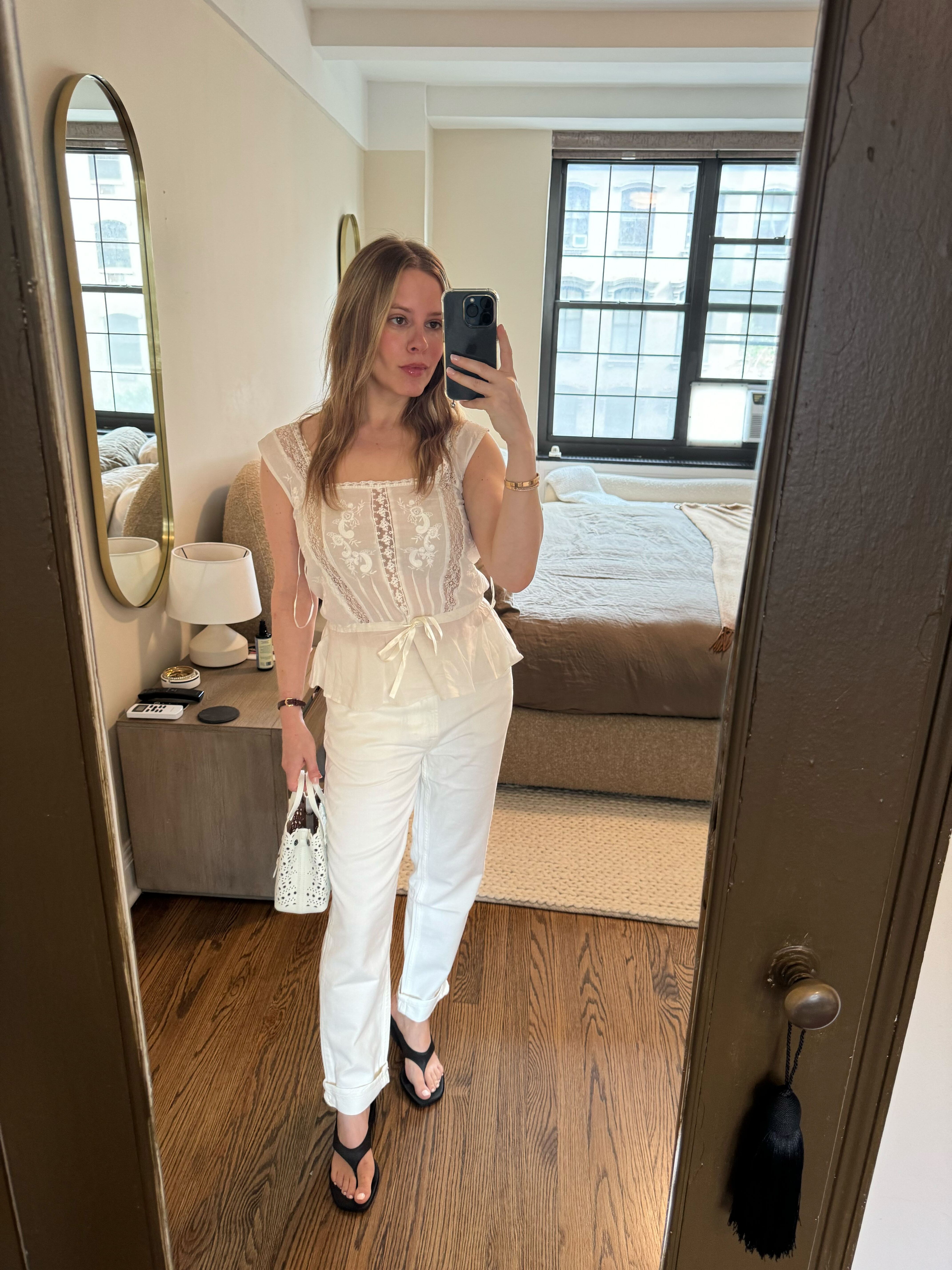 Nikki wears thong wedges, white jeans, and lace top.