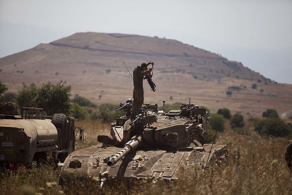 An Israeli soldier stands on a Merkava tank on the Israeli-Syrian border near Quneitra on June 22, 2014. 