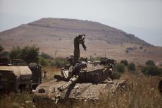 An Israeli soldier stands on a Merkava tank on the Israeli-Syrian border near Quneitra on June 22, 2014. 