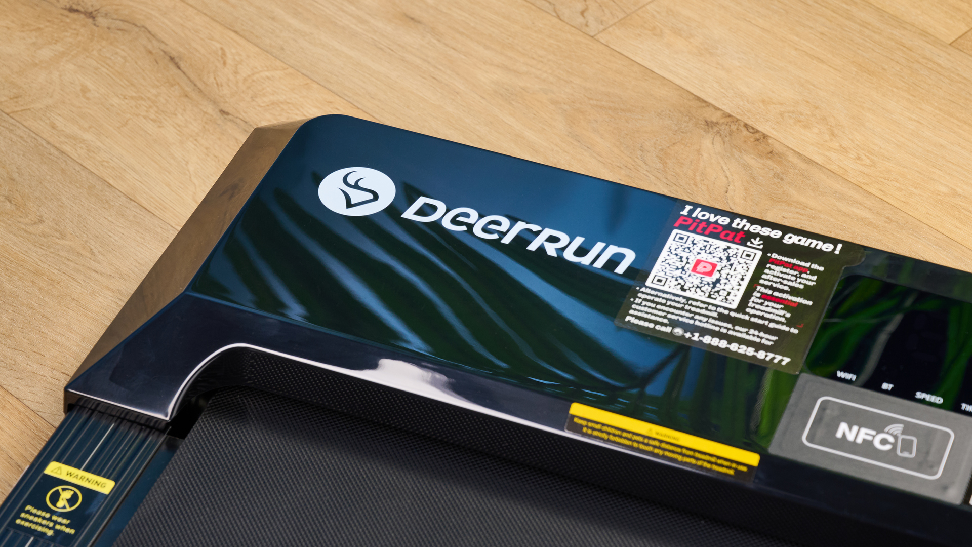 the deerrun q1 mini under desk treadmill walking treadmill in a home office with a blue wall and wooden floor