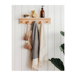 Simple wooden peg rail with relaxed, boho towels and natural brushes.