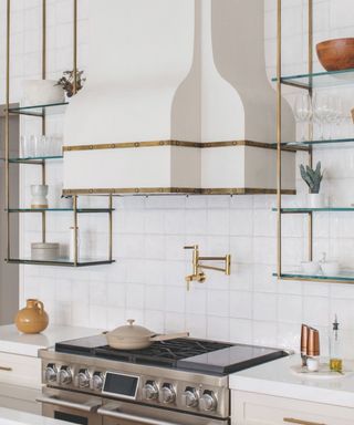 white tiled kitchen with white extractor hood and open shelves and pan filler