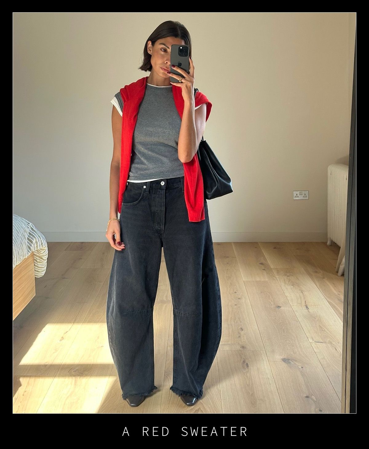 Woman in black jeans, gray tee, and red sweater.