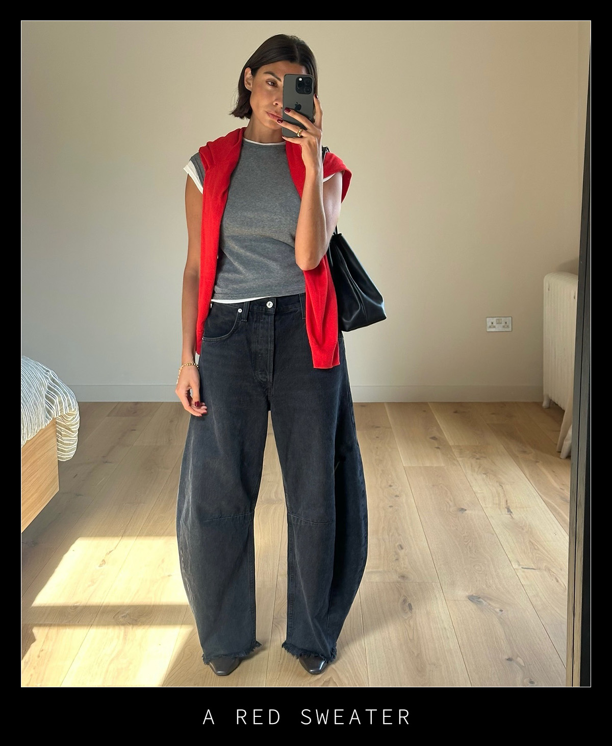 Woman in black jeans, gray tee, and red sweater.