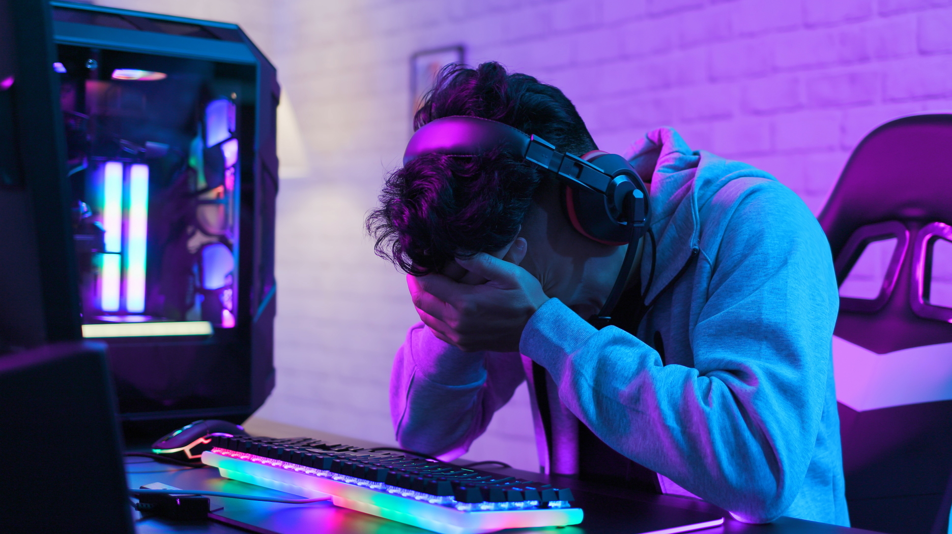 Upset PC gamer with head in hands by his PC