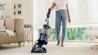 Shark NV360 Navigator Lift-Away Deluxe Upright Vacuum being used by a person to vacuum carpet