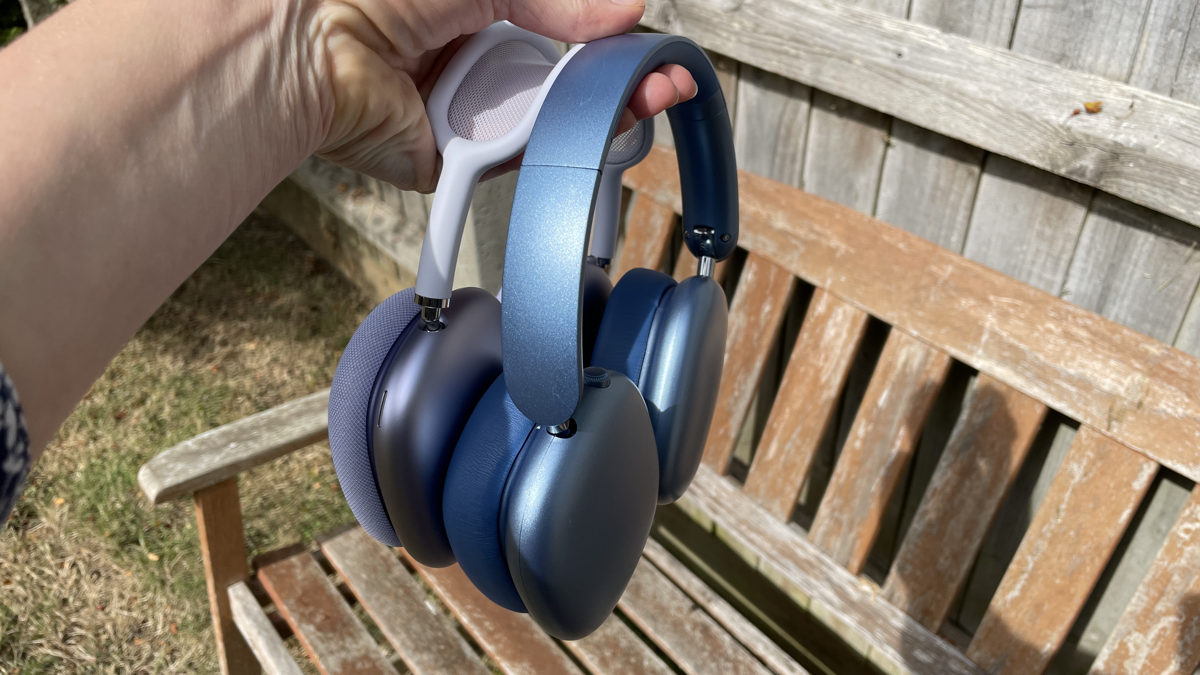 Wentronic YO1 (AirPods Max dupe) headphones in blue with AirPods Max nearby to compare and contrast their looks, outside on a sunny day