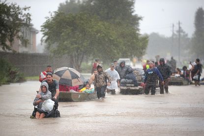 People make their way through a flooded Houston neighborhood.