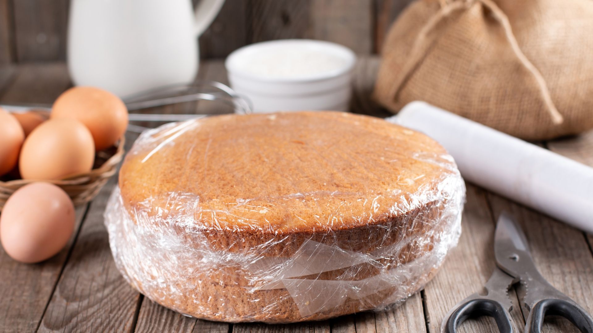 A sponge cake defrosting on a worktop