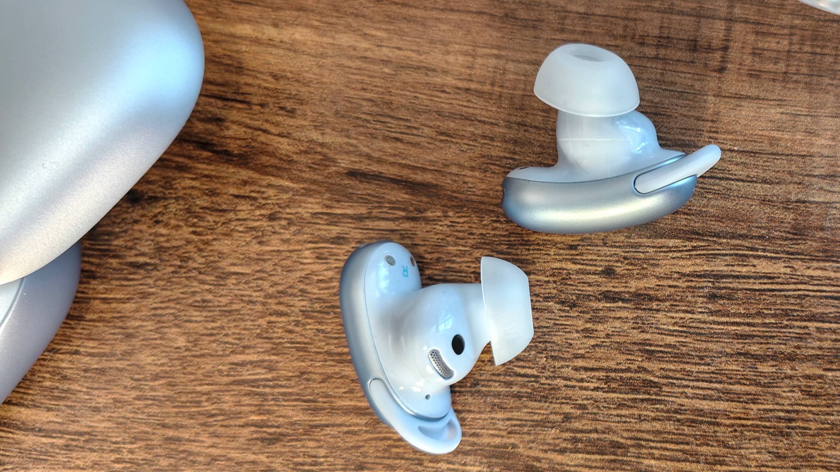 The Anker Soundcore Liberty 5 Pro on a shelf, next to some glasses.