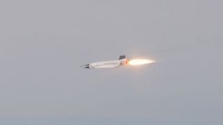 A small prototype fires its rocket engine during a high supersonic test flight.