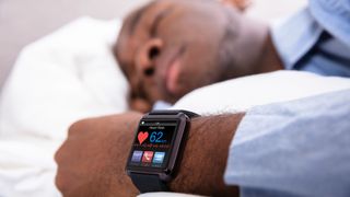 Man using a fitness tracker to monitor sleep