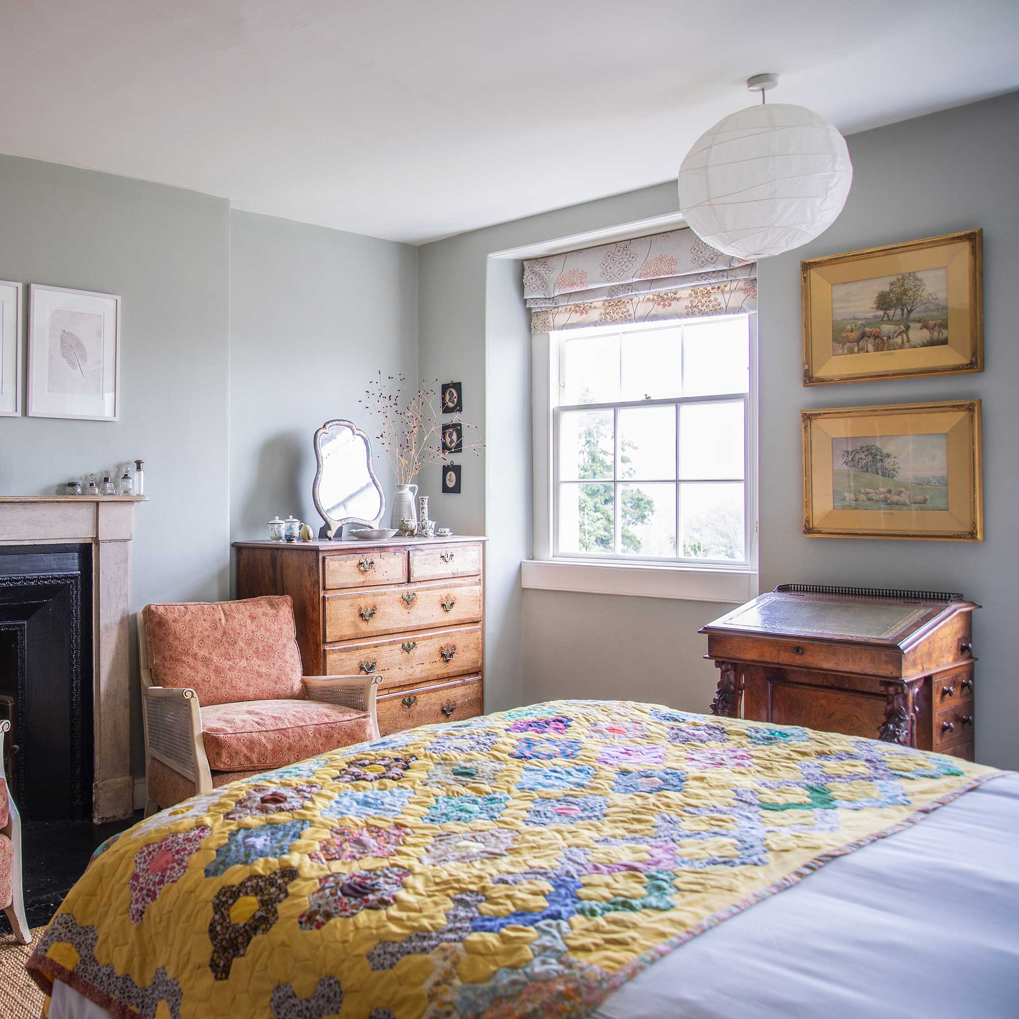 bedroom in a Georgian house with antique furniture, pale blue walls and quilted valance