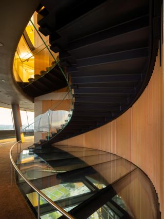 Inside the Space Needle featuring a glass floor and curved stair case.