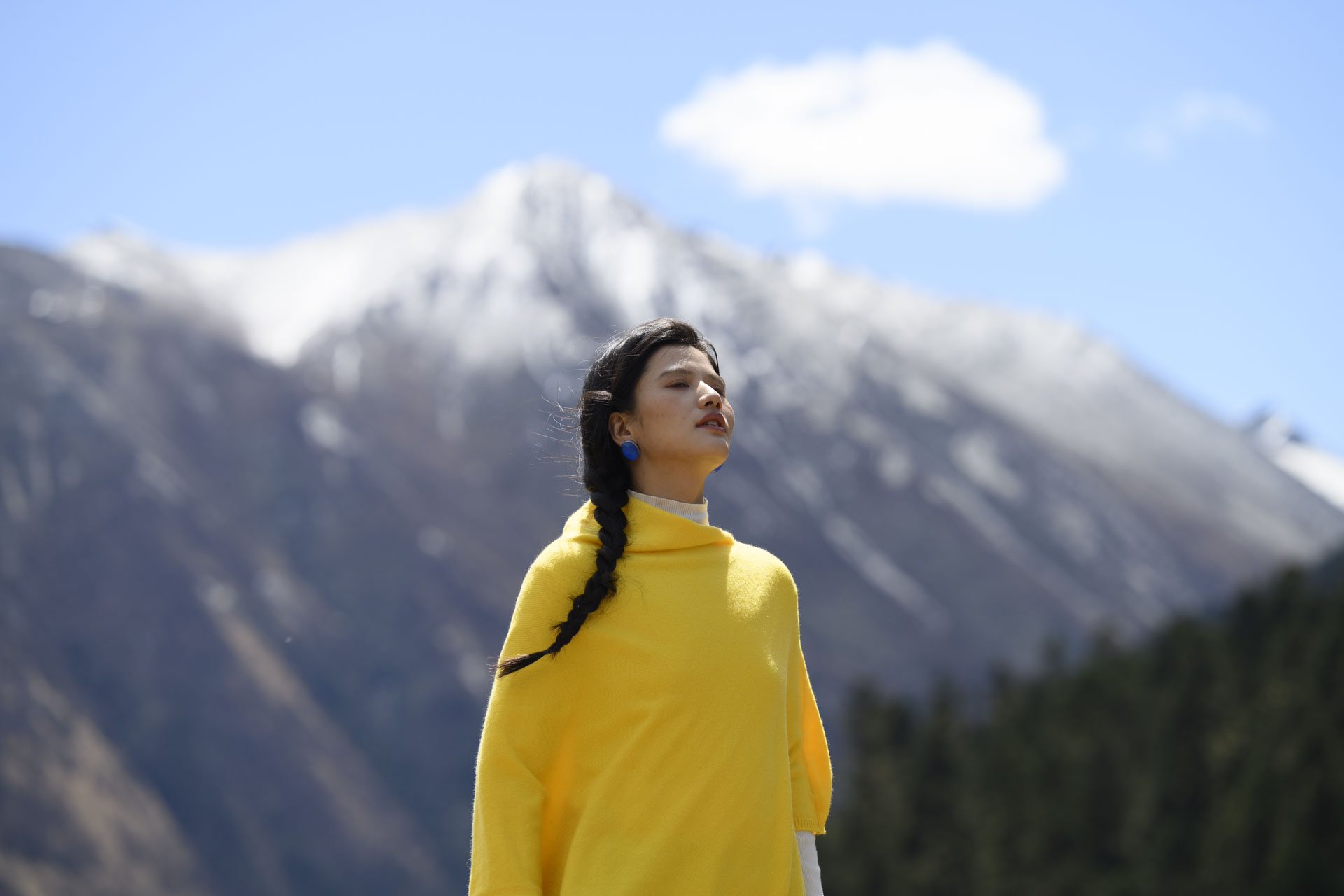 Nikon Z 70-200mm f/2.8 VR S II image gallery: female model in a yellow shawl in front of snow-covered mountains