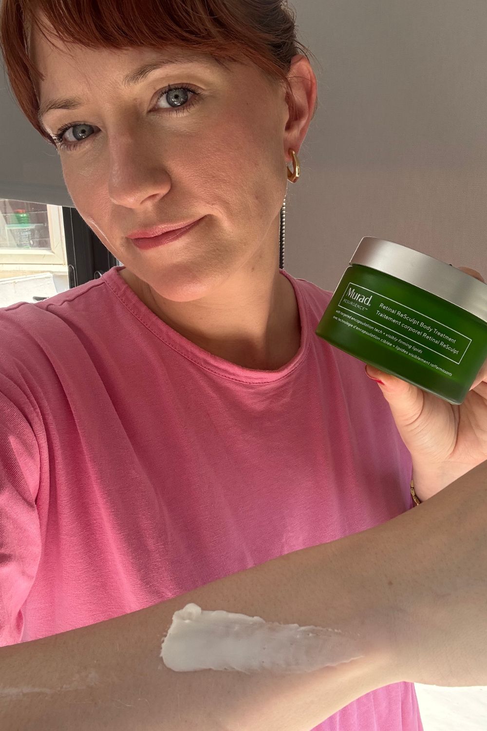 Matilda with a tub of murad resculpt body and a smear on her arm