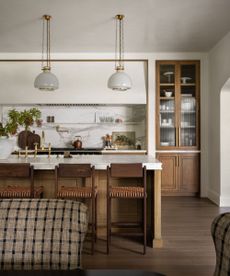 A wood and white kitchen with marble countertops and backsplash by Studio McGee