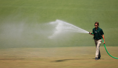 A greenskeeper sprays water during a practice round prior to the Masters at Augusta National Golf Club