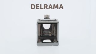 A small cube-shaped lens adapter for a camera. It has a glass front panel and a silver exterior. 