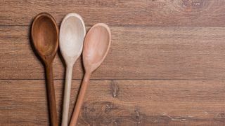 three wooden spoons on a wooden surface