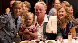 Philip Seymour Hoffman and Amy Adams sit at a dinner table in The Master