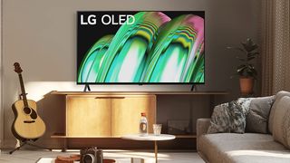 LG OLED TV in a living room with furniture and a guitar