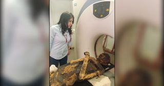 Radiologist Sahar Saleem stands with the mummy of Seqenenre Taa II during CT scanning.