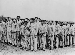 Prisoners stand for roll call at Buchenwald concentration camp. Two prisoners in the front row hold a friend, because fainting often provided the camp with an excuse to "liquidate" so-called "useless" inmates. This photo is dated to between 1938 and 1941.