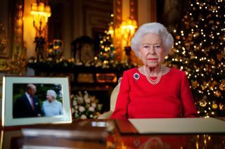 WINDSOR, ENGLAND - DECEMBER 23: Queen Elizabeth II records her annual Christmas broadcast in the White Drawing Room at Windsor Castle on December 23, 2021 in Windsor, England. The photograph on the desk is of The Queen and the Duke of Edinburgh, taken in 2007 at Broadlands, Hampshire, to mark their Diamond Wedding Anniversary. (Photo by Victoria Jones - Pool/Getty Images)