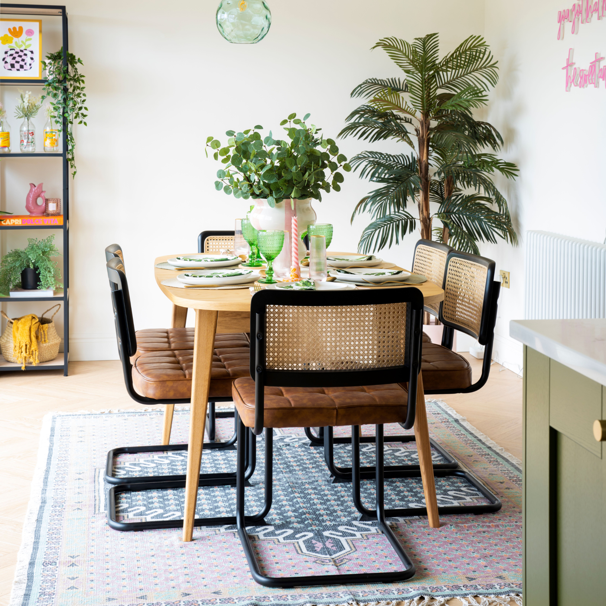Dining room with rattan chairs, wooden dining table, and rug underneath