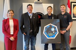 Canadian Space Agency president Lisa Campbell poses with Dave Courchene III, leader of the Turtle Lodge and artist Henry Guimond, who holds his painting, as well as astronaut Jeremy Hansen.