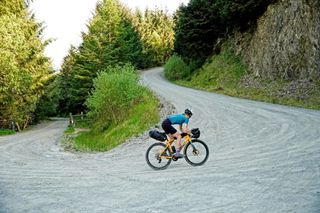 Anna Abram cycling up one of the hairpin gravel tracks along the Trans Cambrian Way