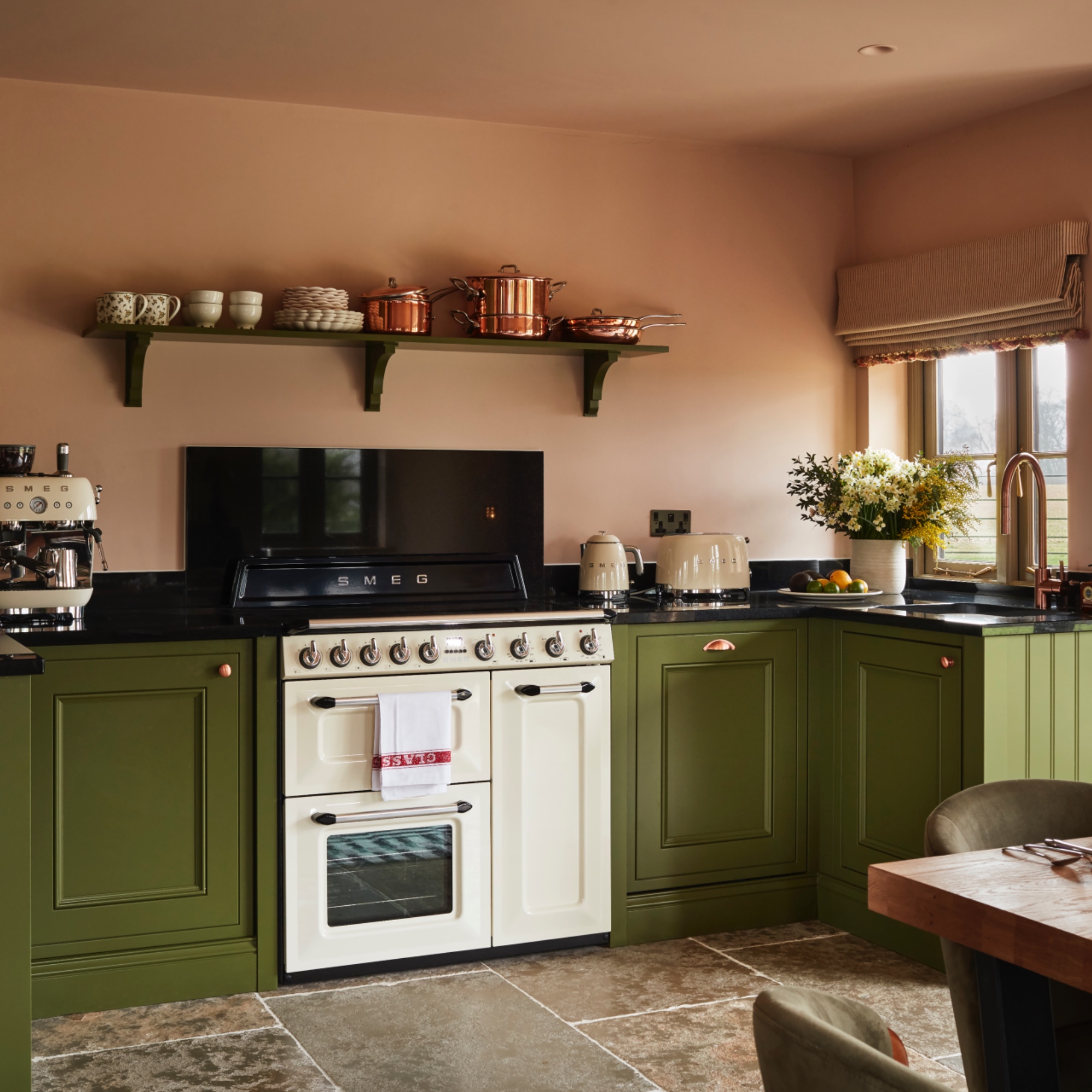 pink and green kitchen with Shaker style units, pink walls, white range cooker, stone flooring