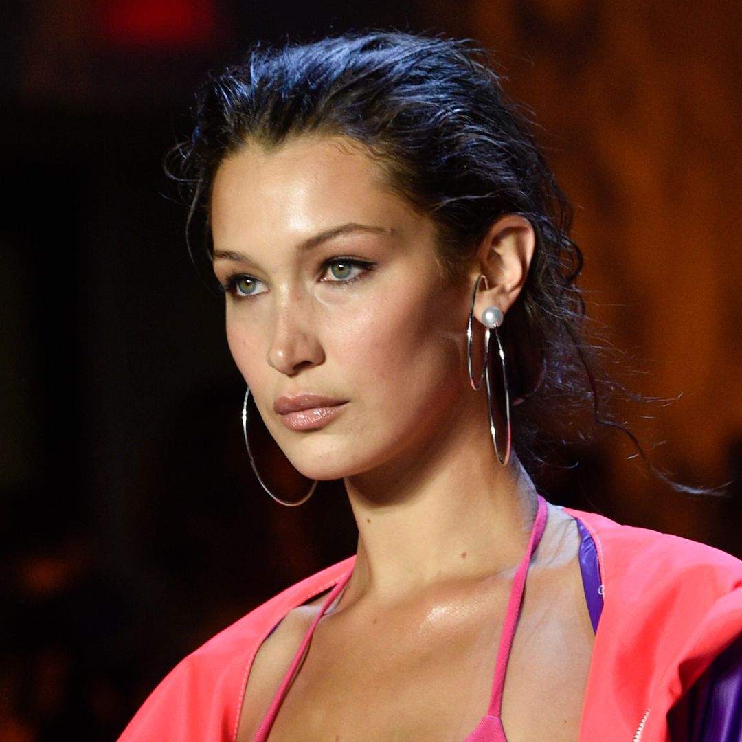 Model Bella Hadid walks the runway in a bikini and neon tracksuit top