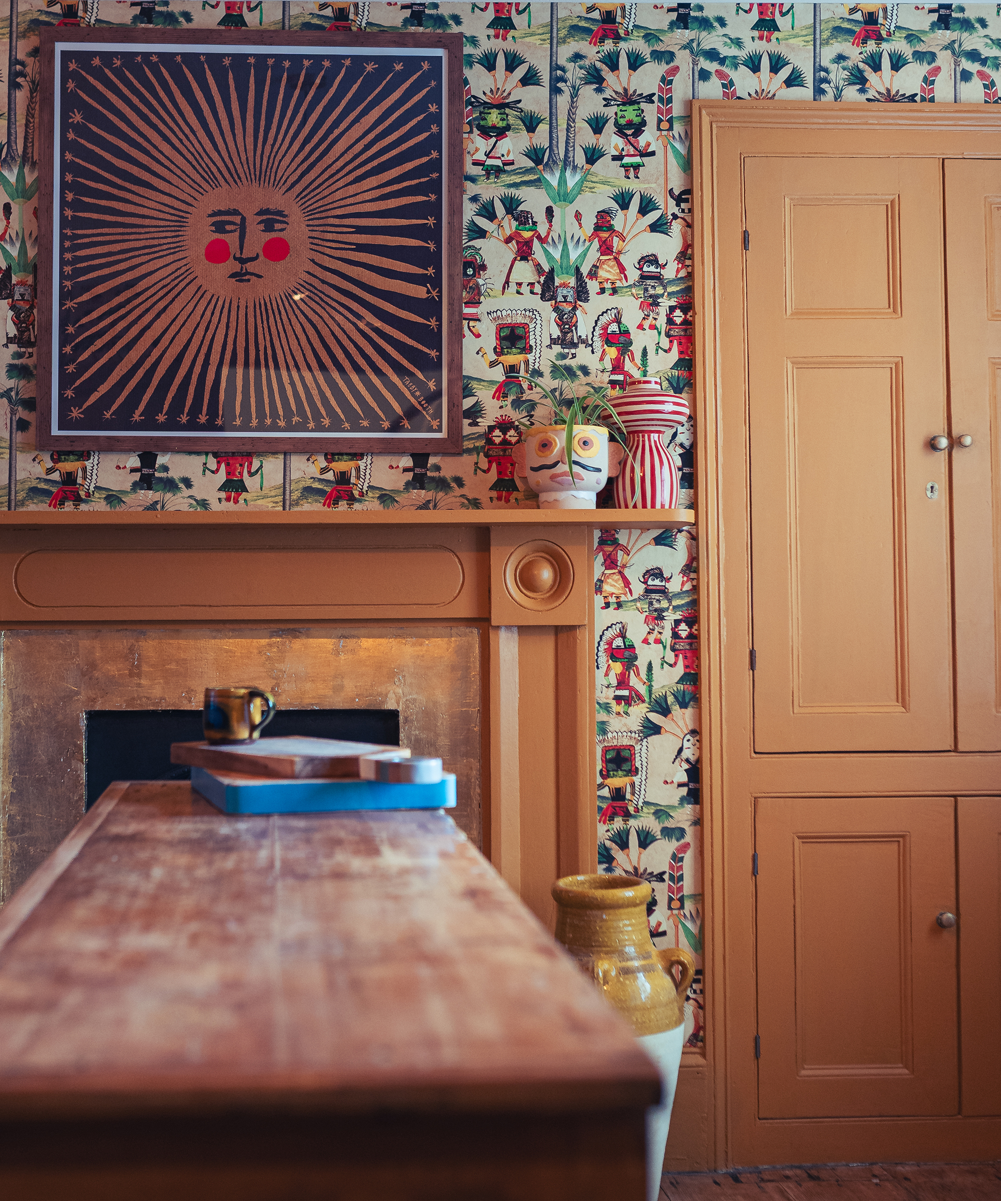 patterned living room with graphic art above a fireplace