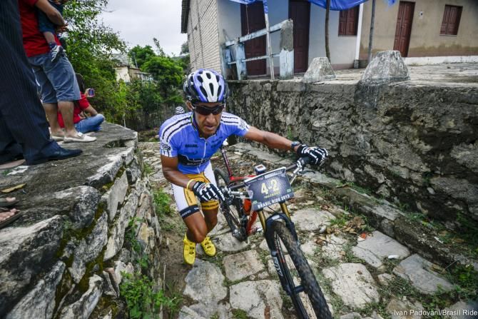 A rider runs up the climb